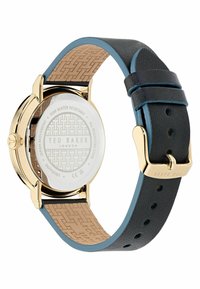 Bracciale in pelle nera con accenti blu, cassa in acciaio inossidabile con finitura dorata, retro decorate e vetro trasparente. Resistente all'acqua fino a 50 metri.