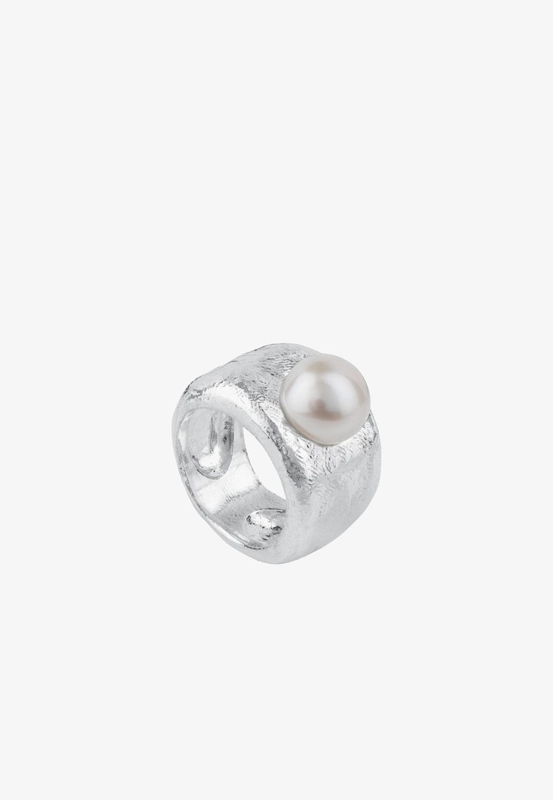 Anillo de plata con una superficie texturizada y un acento de perla blanca redonda. Presenta una forma gruesa y orgánica con espacios abiertos para una mejor transpirabilidad.