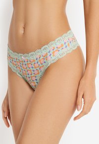Μικροσκοπικό εσώρουχο με δαντελωτή επένδυση και ζώνη μέσης σε μέντα πράσινο, με πολύχρωμο μοτίβο επαναλαμβανόμενων κύκλων σε απαλό ύφασμα.