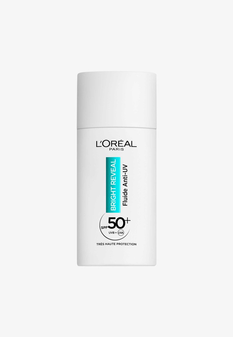 Bouteille de crème solaire au design épuré et blanc. Présente un texte aqua indiquant "Bright Reveal", SPF 50+ et des symboles de protection UV sur l'étiquette.