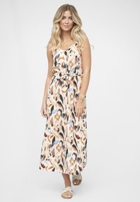 Mekko, jossa on abstrakti kuvio lämpimissä persikan, oranssin ja mustan sävyissä. Materiaali vaikuttaa kevyeltä ja siinä on säädettävät hihnat.