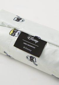 Svilena torbica s crno-žutim crtaćim figurama na svijetlosivoj pozadini, s crnom oznakom brenda koja uključuje "Disney" i "Karl Lagerfeld."