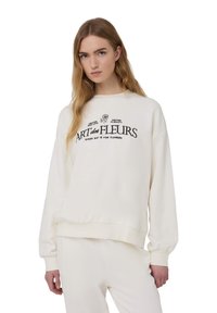 Felpa in cotone crema con polsini e orlo a costine. Presenta la scritta nera "ART des FLEURS" e accenti floreali sulla parte anteriore.