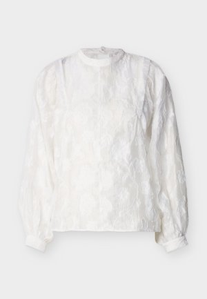 Blusa blanca de manga larga con textura de encaje floral, cuello alto, mangas abullonadas fruncidas y puños con botones sobre fondo liso.