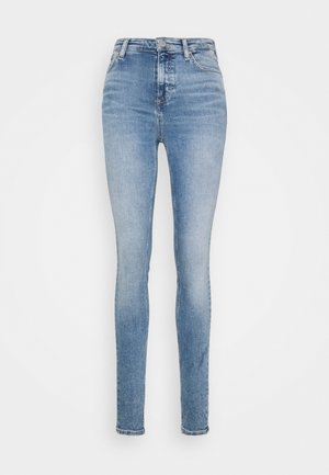 Lichtblauwe high-waisted skinny jeans met knoop en rits aan de voorkant, voor- en achterzakken en vervaagde details.