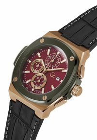 Orologio da uomo con un quadrante bordeaux, lancette dorate e subquadranti; cassa in tono bronzo, cinturino in pelle scura con accenti testurizzati.