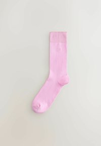 Calcetín de algodón rosa con puño acanalado, textura suave y un detalle sutil de logo en el lateral. Presenta un diseño clásico de longitud media.