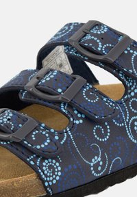 Dark blue sandals with two adjustable straps, featuring a swirl pattern in lighter blue tones and a textured cork footbed.