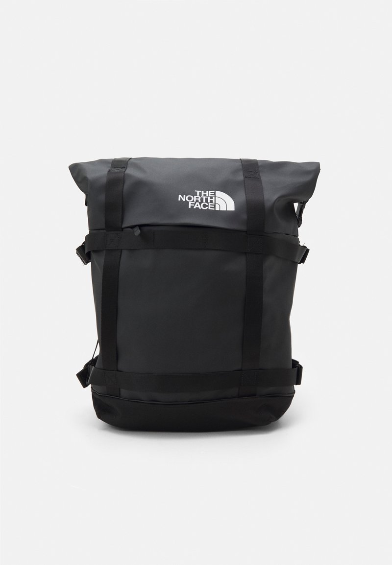 Sac à dos noir à fermeture roulante avec boucles avant, sangles et logo The North Face centré sur le panneau avant supérieur.