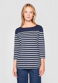 Tamsiai mėlyna ir balta juostuota ilgomis rankovėmis palaidinė su apvaliame iškirpime, pagaminta iš minkštos medžiagos, pasižyminti laisvu siluetu ir trijų ketvirčių rankovėmis.