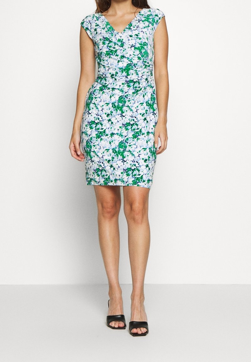 Blommig klänning med v-ringning, korta ärmar och figurnära silhuett. Tyget har gröna och blå blommönster på en ljus bakgrund.