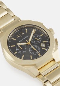 Goldfarbener Edelstahl-Chronograph mit schwarzem Zifferblatt, drei Subdials und Datumsanzeige. Mit markanten Stundenmarkierungen und Zeigern.
