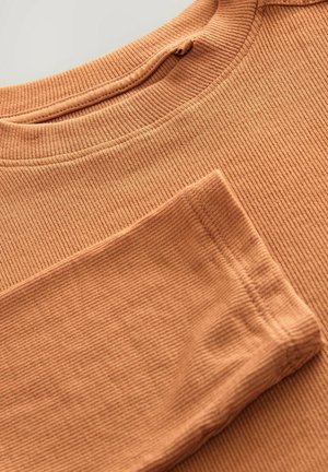 Top à manches longues à côtes dans une teinte orange chaude, avec un col rond et une coupe décontractée. Texture douce avec des coutures visibles et un design simple.
