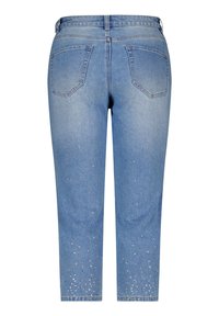 Jeans en denim bleu clair à coupe droite, présentant des poches arrière et des embellissements de strass au niveau de l'ourlet.