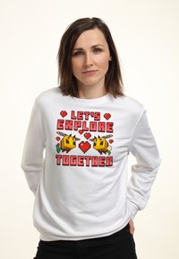 Felpa bianca a maniche lunghe con una grafica di un'ape pixelata colorata, cuori rossi e il testo "ESPLORIAMO INSIEME" in lettere grassetto.