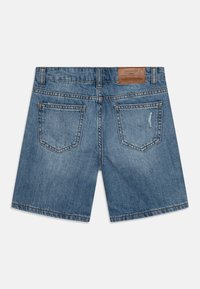 Blå denimshorts med en klassisk kutting, to baklommer og en lærlabel på linningen. Lys falming og subtile whiskering-detaljer.