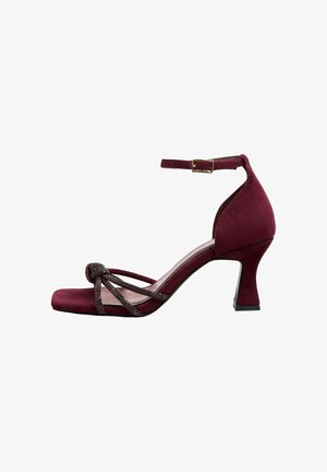 Burgundy mokkanahka korkokenkä, jossa on neliömäinen kärki, sivuvalehdinta korostava nauha ja kapea nilkkahihna. Varusteena kestävä, teksturoitu korko.