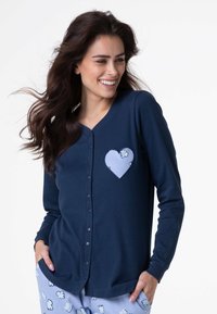 Cardigan a maniche lunghe blu navy con chiusura frontale a bottoni e tasca a forma di cuore azzurro chiaro decorata con un motivo nuvola. Tessuto con texture morbida.
