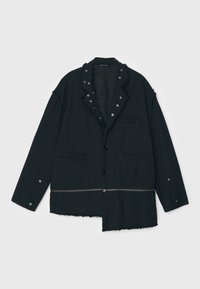 Schwarze Jacke mit strukturierter Oberfläche, ausgestattet mit einem mit Fransen besetzten Kragen, Druckknopfdetails, zwei vorderen Taschen und einem asymmetrischen Saum.