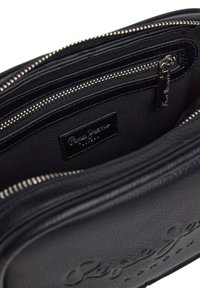 Borsa a mano in pelle nera con chiusura a zip, superficie testurizzata, tasca interna e un piccolo etichetta del marchio impressa.