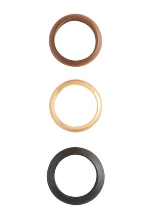 Three round rubber O-rings in brown, beige, and black arranged vertically on a white background.