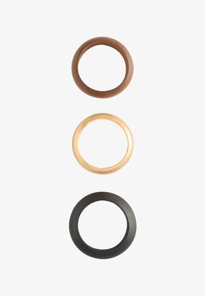 Three round rubber O-rings in brown, beige, and black arranged vertically on a white background.