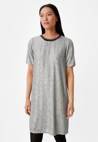 Abito d'argento in paillettes con maniche corte, scollatura rotonda accentuata da dettagli neri. Tessuto liscio, vestibilità ampia, taglio sopra il ginocchio.