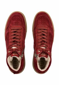 Une paire de baskets en daim rouge à lacets avec une semelle beige et une fermeture éclair sur le côté, dotées d'un intérieur en fourrure blanche.