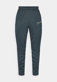 Spodnie sportowe Nike, ciemnoszare, zwężane, z elastycznym pasem, dwie boczne kieszenie, żółty detal logo na górnej lewej udzie.