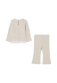 Beige lange mouw top met knoopdetails en een sleutelgat achteraan, samen met bijpassende flare broek, plat gelegd op een witte achtergrond.