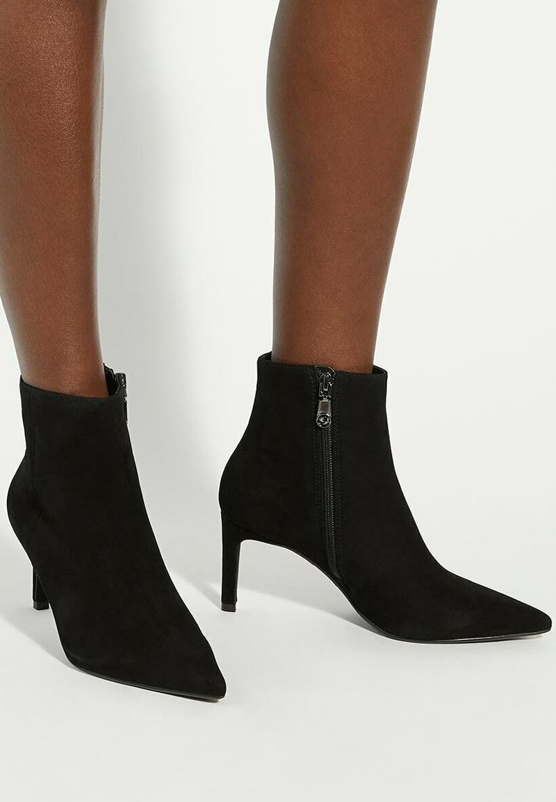 Black suede ankle boots with a pointed toe and a slim heel. Features a side zipper and smooth texture, offering a streamlined silhouette.