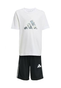 Biała koszulka z krótkim rękawem z szaro-camuflażowym logo adidas, zestawiona z czarnymi szortami z białymi akcentami oraz małym logo adidas po boku.