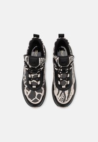 Svarta och krämfärgade sneakers med ett texturerat mönster med ränder och prickar, snörningsdesign, vadderad krage och en slitstark gummisula.