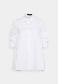 Camicia bianca con colletto, maniche corte e texture arricciata nei polsini. Realizzata in cotone morbido.