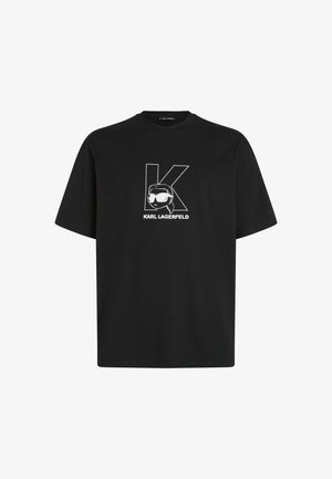 Čierne bavlnené tričko s bielym grafickým dizajnom písmena "K" a postavy so slnečnými okuliarmi. Krátke rukávy, okrúhly výstrih.