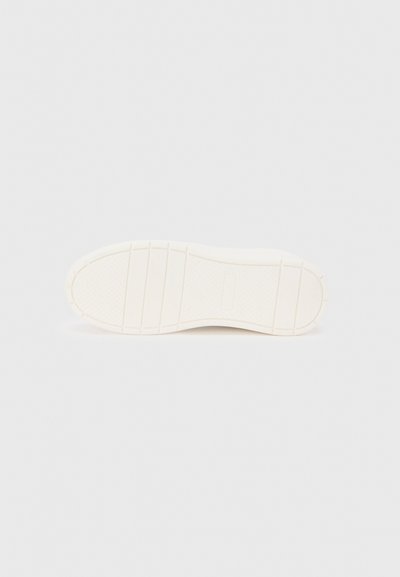 Πάτος παπουτσιού, κυρίως λευκός με διακριτική υφή. Διαθέτει αυλακώσεις και λείο φινίρισμα, σχεδιασμένο για λαβή και πρόσφυση.