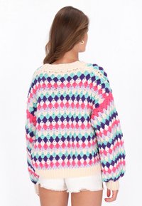 Kolorowy dziany sweter z wzorem diamentów w odcieniach różu, fioletu i niebieskiego, z kremowym ściągaczem na dole i bufiastymi rękawami.