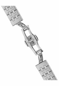 Bracelet de montre en métal argenté avec une texture brossée, présentant des motifs découpés rectangulaires et un mécanisme de fermoir sécurisé au centre.