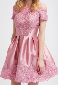 Pink satin dress with off-the-shoulder sleeves, featuring intricate lace embroidery and a flared skirt with decorative hem details.