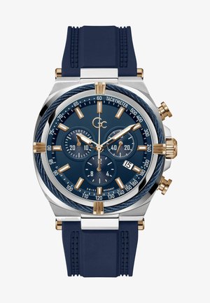 Orologio cronografo da uomo con cinturino in silicone blu, accenti dorati e quadrante blu con tre sottodial e marcature tachimetriche.