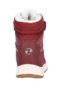 Bottine synthétique rouge avec doublure en polaire blanche rembourrée, couture contrastée et logo gris au niveau du talon arrière. Semelle en caoutchouc.