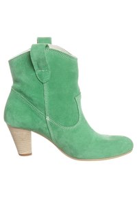 Bottine en daim vert avec un haut incurvé, des coutures latérales, une languette d'extraction et un talon en bois clair texturé. Bout lisse et forme profilée.