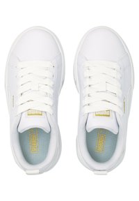 Baskets blanches avec un dessus synthétique texturé, des lacets blancs plats et une semelle intérieure bleu clair. Présente un logo doré sur la languette.