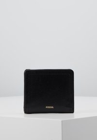 Zwarte leren portemonnee met zichtbare stiksels, rechthoekige vorm, kaartvak aan de voorkant en reliëf "FOSSIL" logo in het goud aan de onderkant.