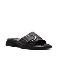 Sandale slide en cuir noir avec petit talon bloc et grande boucle argentée sur la large bride couvrant les orteils sur fond blanc.