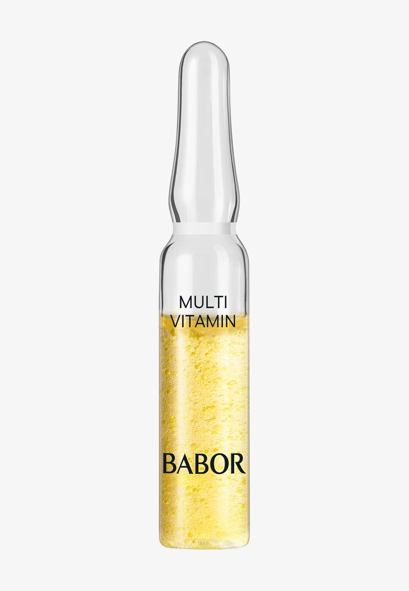 Klar glasampull som innehåller en gul vätska med bubblor, märkt "MULTI VITAMIN" och "BABOR" i svart text.