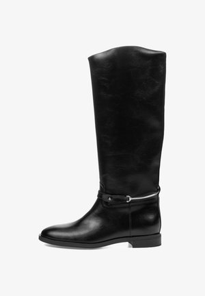 Bota de cuero negra hasta la rodilla con tacón bajo y una correa decorativa con detalle metálico alrededor del tobillo.