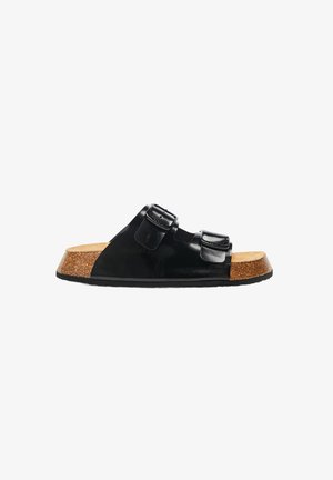 Sandale à plateforme en cuir verni noir avec deux boucles ajustables, semelle en liège et semelle en caoutchouc. Bout arrondi avec une texture supérieure lisse.