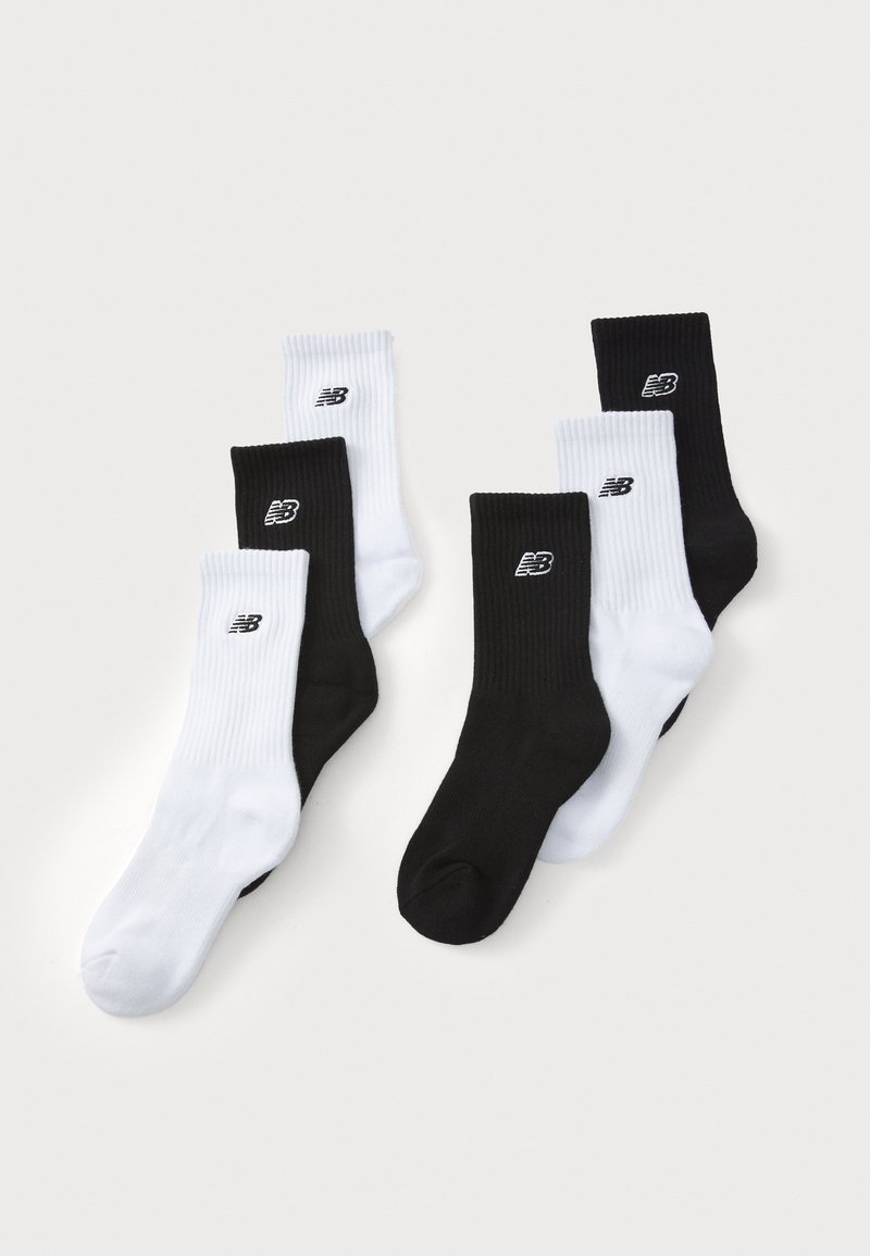 Black and white crew socks set, ribbed texture, featuring a small logo on the ankle. Four total: two black, two white.