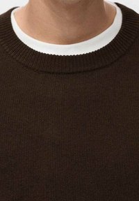 Brązowy sweter z dzianiny z prążkowanym okrągłym dekoltem, o miękkiej fakturze, z widoczną białą koszulą pod spodem na dekolcie.